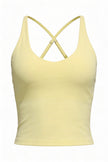 Yellow tank top with criss-cross straps on a white background