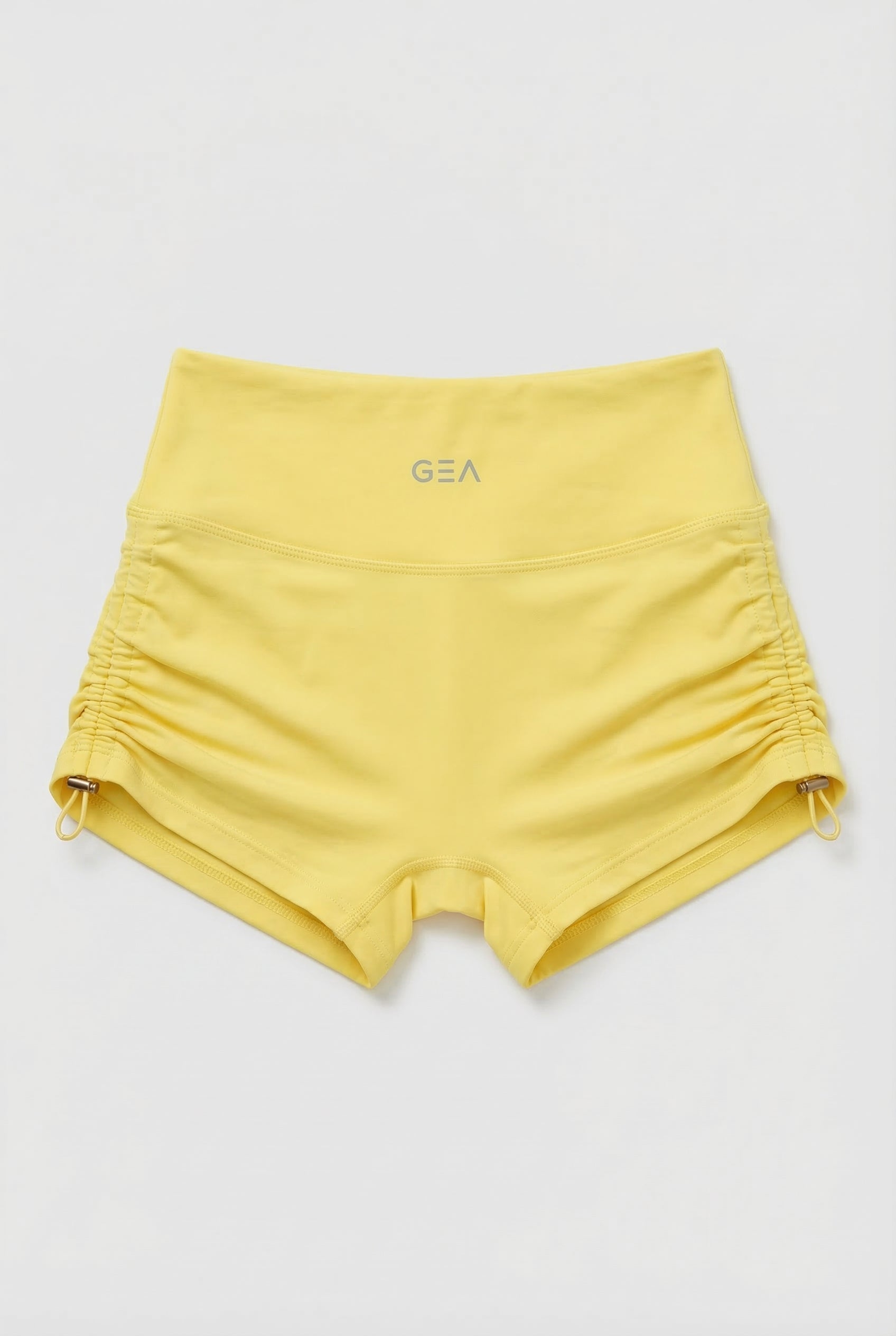 Yellow shorts with a brand logo on a light gray background