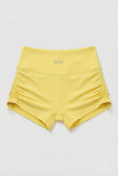 Yellow shorts with a brand logo on a light gray background